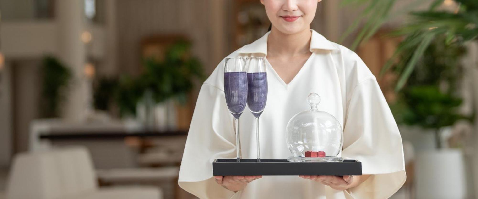 盛泰澜苏梅查汶海滩度假村酒店 外观 照片 A server holding a tray of wine glasses